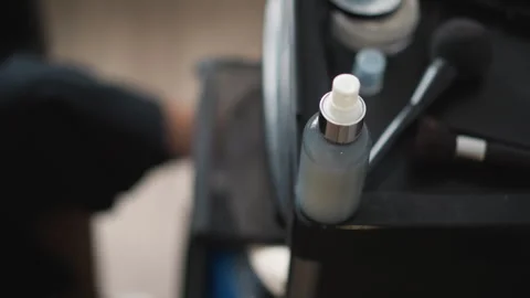 Close up makeup spray bottle and organized black vanity with brushes compacts in Stock Footage 346730237