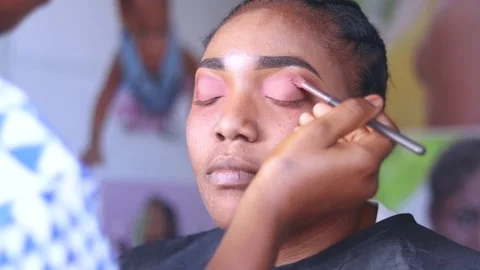 Close up of makeup stylist applying makeup treatment on face of an African lady. Stock Footage 217876557