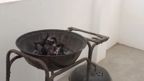 Close-up making air with a blower to light the flame of a grill with charcoal in Stock Footage 155808024