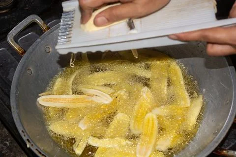 Close up of making a light snack of yellow banana chips Stock Photos