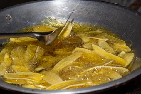 Close up of making a light snack of yellow banana chips Stock Photos