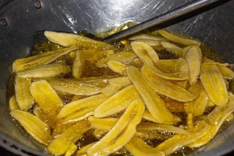Close up of making a light snack of yellow banana chips Stock Photos