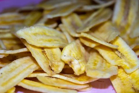 Close up of making a light snack of yellow banana chips Stock Photos
