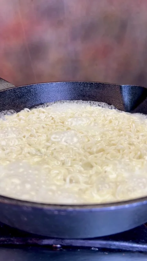 Close Up In the Making of Maggi  Noodle, Boiling Dry Noodle, in a pan. Stock Footage 287305961