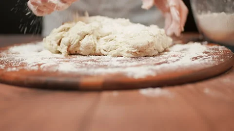 Close-up of making pizza dough, preparing and mixing the dough with flour in 4K. Stock Footage 137427296