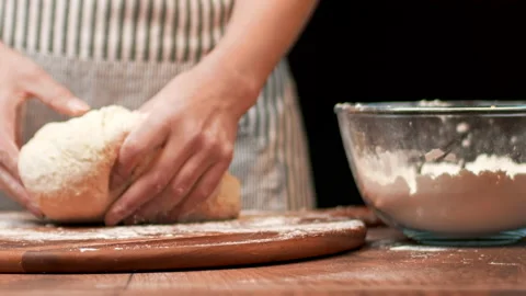 Close-up of making pizza dough, preparing and mixing the dough with flour in 4K. Stock Footage 137428005