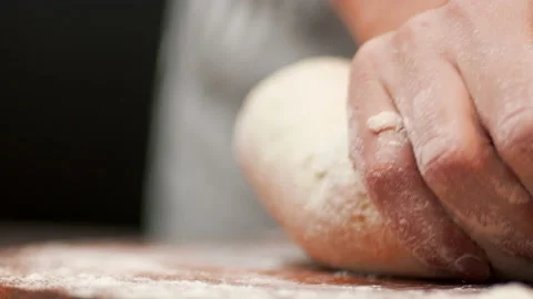 Close-up of making pizza dough, preparing and mixing the dough with flour in 4K. Stock Footage 137428543