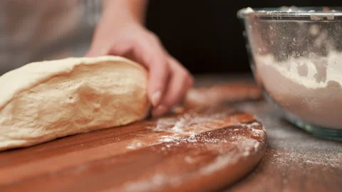 Close-up of making pizza dough, preparing and mixing the dough with flour in 4K. Stock Footage 137428641