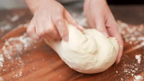 Close-up of making pizza dough, preparing and mixing the dough with flour in 4K. Stock Footage 137428911