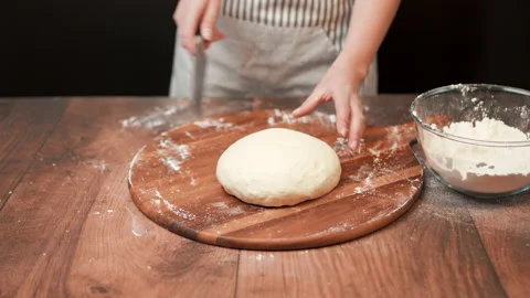 Close-up of making pizza dough, preparing and mixing the dough with flour in 4K. Stock Footage 137428934
