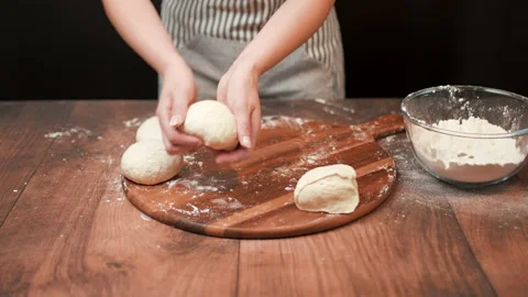 Close-up of making pizza dough, preparing and mixing the dough with flour in 4K. Stock Footage 137429123