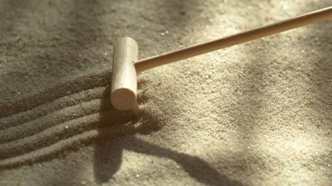 Close-up making sand zen garden using mini wooden rake with shadows and sunlight Video stock 264084267
