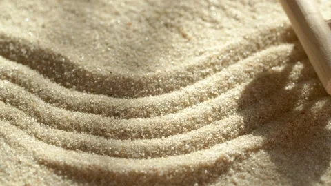 Close-up making sand zen garden using mini wooden rake with shadows and sunlight Stock Footage 277183833