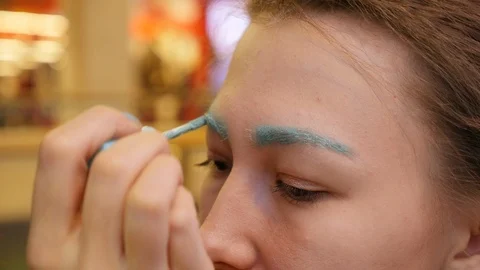 CLOSE UP Making a strange make up Young girl Eyebrows into blue colour Vidéo 91916295