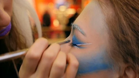 CLOSE UP Making a strange make up Young girl Eyelids into blue colour Vidéo 91917028