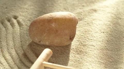 Close-up making zen garden with sand and stone using mini bamboo wooden rake Vídeo Stock 266870399