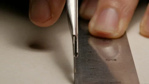 Close-up of male architect hands cutting white paperboard with cutter knife a Stock Footage 132548434