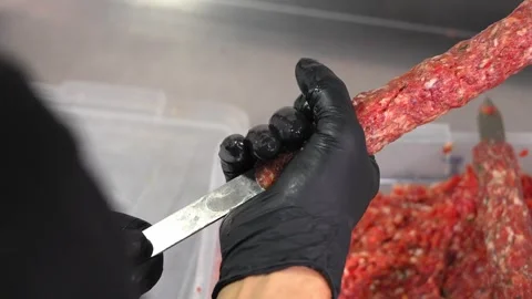 Close-up of male chef's hands squeezing minced meat and spreading it skewer Stock Footage 267672911