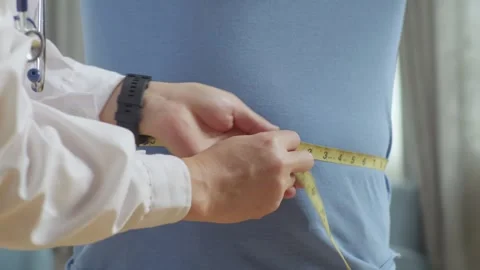 Close Up Of Male Doctor'S Hands Using Tape Measuring Fat Male Patient'S Waist Stock Footage 249609842