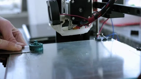 Close-up of a male engineer removes a plastic object printed on a 3D printer. Stock Footage 145811706