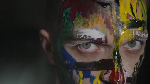 Close up male face on dark background, makeup art, colorful paints Video stock 104022502