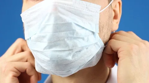 Close-up male face, demonstrate how puts on medical mask, prevention virus Video stock 126998957