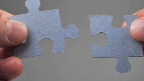 Close-up of male fingers substituting the missing cardboard puzzle on black Stock Footage 224757657