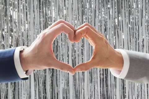 Close up of male gay couple hands showing heart Stock Photos