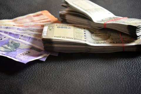Close up of a male hand holding stack of Indian Rupee notes. Cash transaction Stock Photos