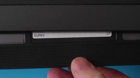 A close -up male hand inserts a video cassette with the inscription porn in.. Video stock 234324693
