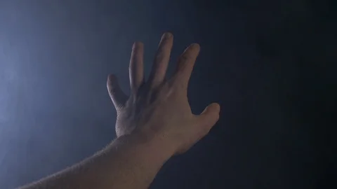 Close Up Of A Male Hand Making Hand Gestures In a Dark Smokey Room Stock Footage 123708342