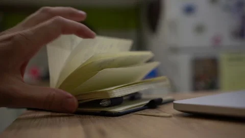 Close up of male hand opening notebook and writing with pen Stockbeeldmateriaal 72571809