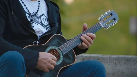Close up male hand playing notes on strings of black guitar Video stock 126130357