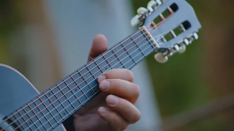 Close up male hand playing notes on strings of black guitar Stock Footage 126130371