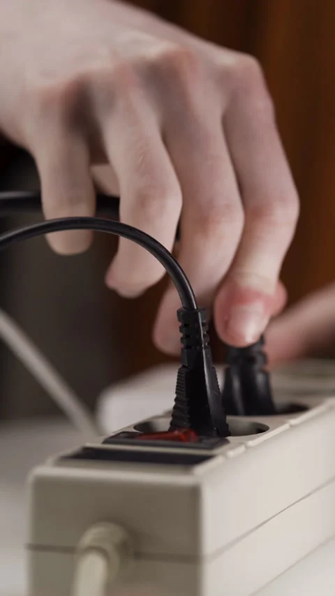 Close-up of male hand plugging a plug into a multiple socket Stock Footage 309541870