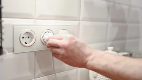 Close-up of male hand plugging a plug into a multiple socket Stock Footage 324625504