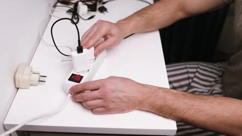 Close-up of male hand plugging a plug into a multiple socket Stock Footage 324625642