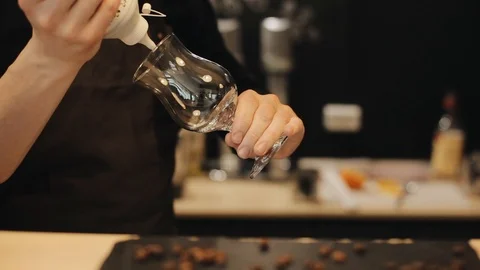 Close-up of male hand squeezing a bottle of chocolate, decorating an empty tulip Video stock 113951232