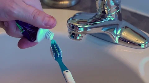 Close up male hand squeezing last drop of toothpaste from tube. Stock Footage 69918320