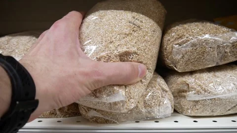 Close-up of a male hand taking a package of wheat groats Stock Footage 309432662
