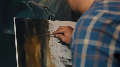 Close up of male hand using art spatula while drawing on easel at studio Stock Footage 155800129