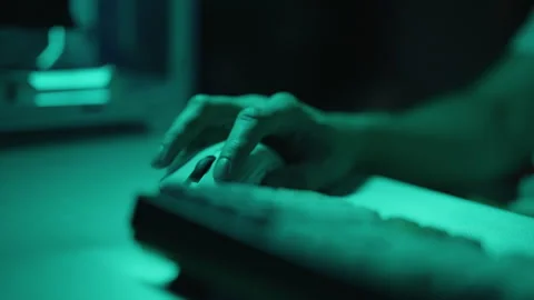 Close-up of male hand using computer mouse in dark room illuminated by monitor Stock Footage 318467708