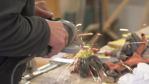 Close up of male hand using a sander to grind metal Stock Footage 132132245