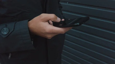 Close up male hand using smartphone on the go. Man on coat 스톡 동영상 119150786