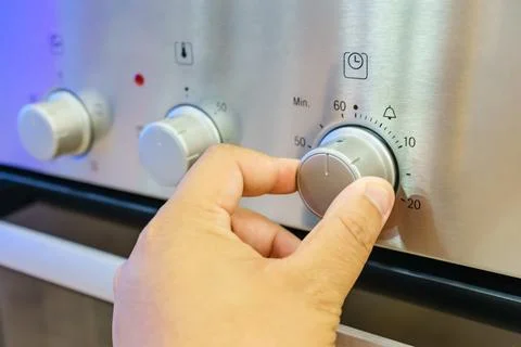 Close up male hand while using the microwave in his kitchen Stock Photos
