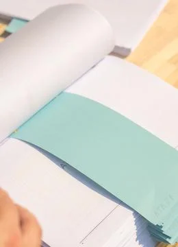 Close up male hand with white stack of papers with blue bookmarks Stock Photos