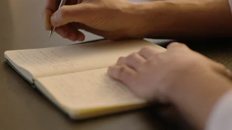 Close-up of male hands and notebook of unidentified young writer. Stock Footage 236772925