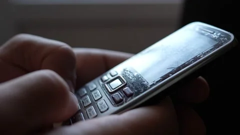 Close-up male hands are using an old push-button mobile phone from the past. Stock Footage 234223012