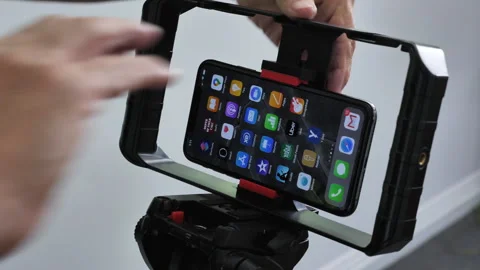 Close-up male hands attach iPhone to camera cage on tripod to shoot video Vídeos de archivo 268351207