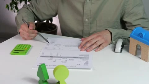 Close-up of male hands checking an estimate and recalculating it on a calculator Stock Footage 312603795